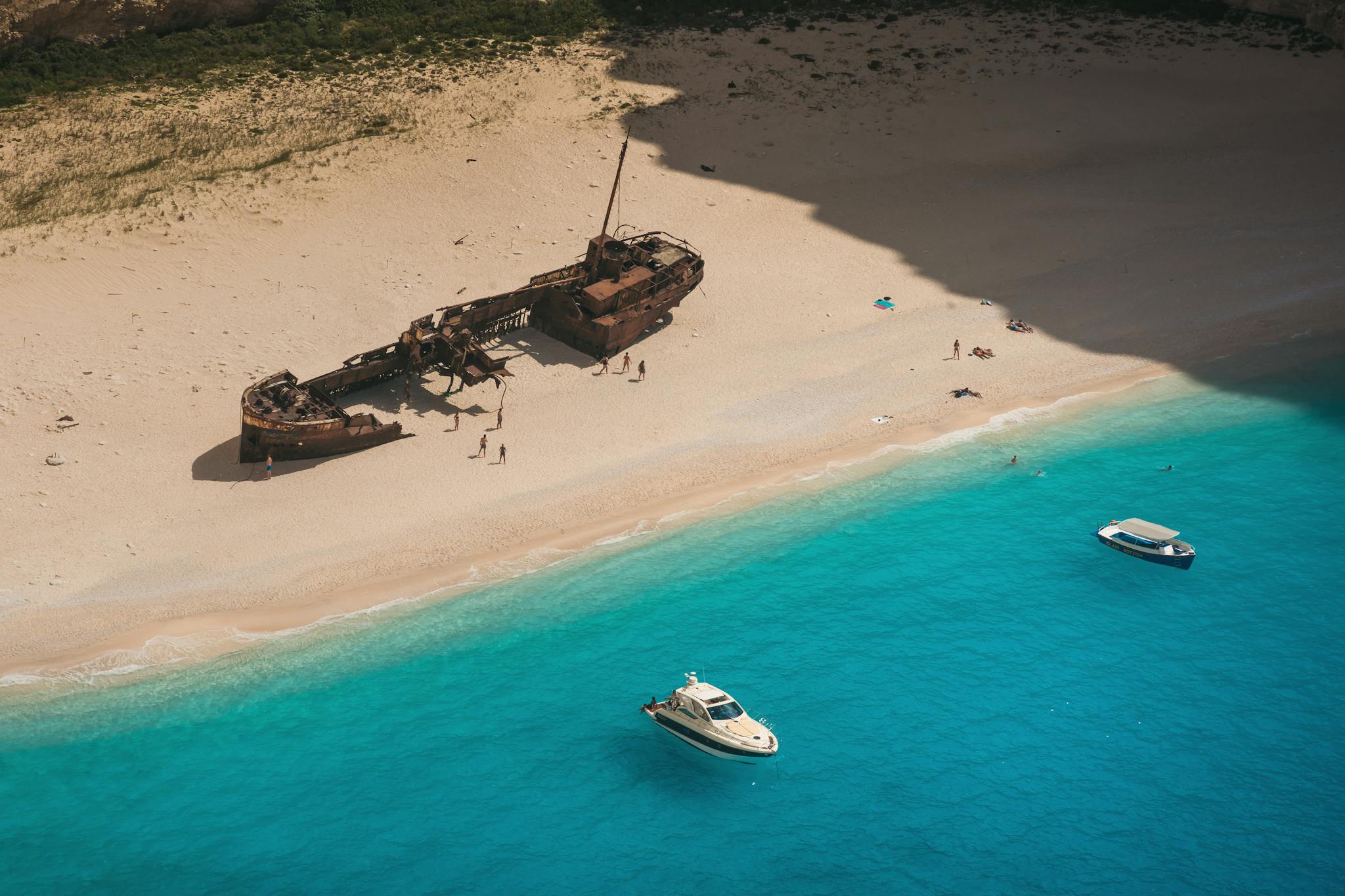 A breathtaking aerial view of Navagio Beach in Zakynthos, Greece, showcasing a famous shipwreck and clear turquoise waters.